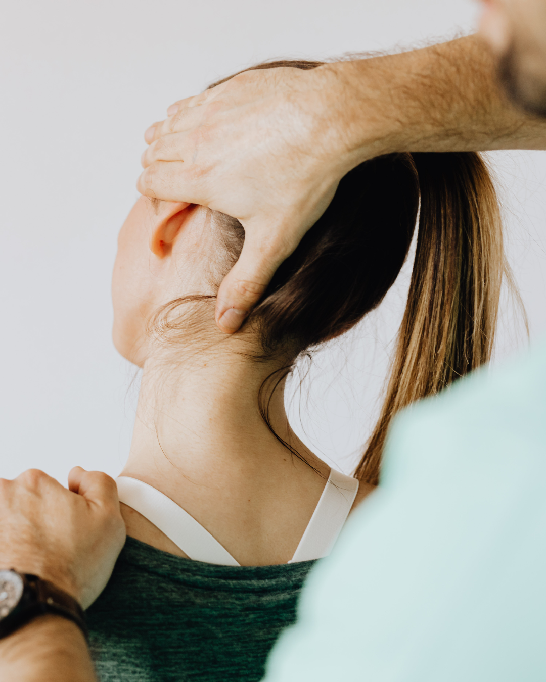 Physiotherapist assessing a patient's neck and jaw for TMJ-related symptoms